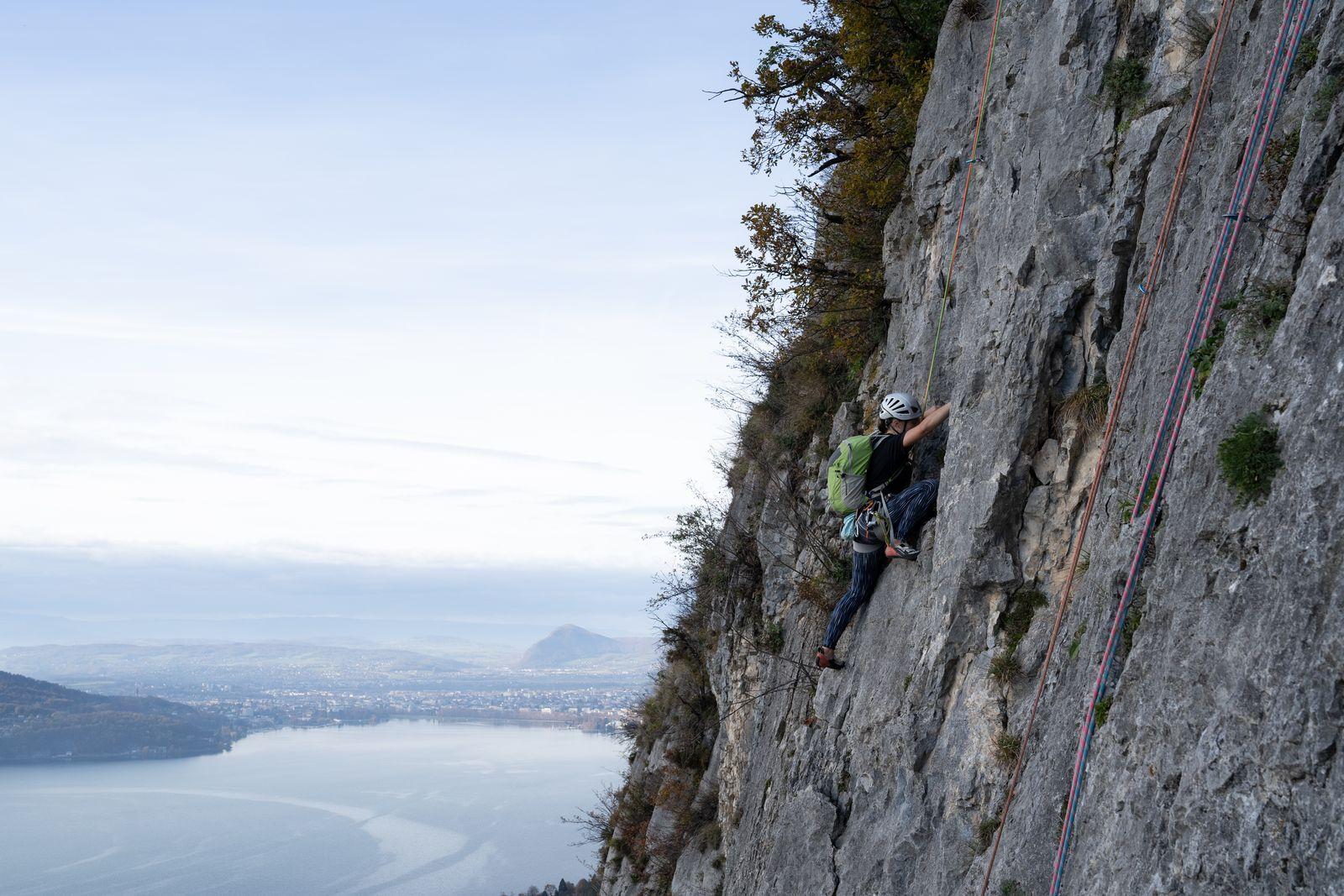 Grimpeuse en falaise avec vue sur le lac